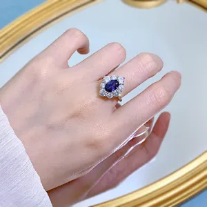 Vista dettagliata di elegante anello in argento 925 con zaffiro blu ovale e pietre.