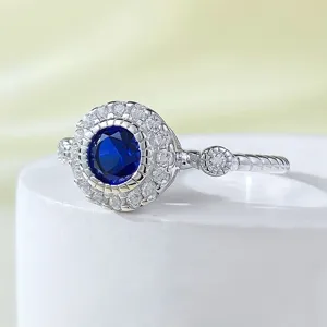 Vista dettagliata di un anello in argento sterling con gemma blu e zirconi brillanti.