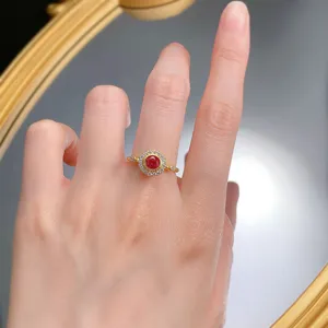 Dettaglio in primo piano dell'anello con gemma rosso sangue di piccione e alone di zirconi.