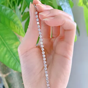 Close-up detail van een sprankelende gesimuleerde diamant tennisarmband in hand.