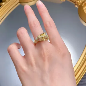 Detailaufnahme eines vergoldeten Drachenrings mit funkelnden Steinen und feiner Optik.