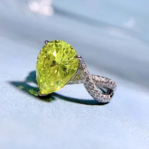 Detailed close-up view of the sparkling olive green pear cut ring with pave band.