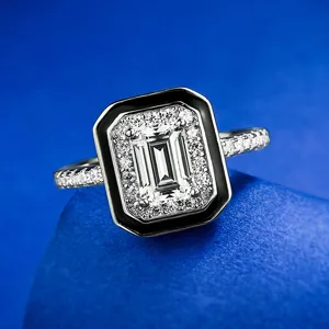 Elegante anillo de talla esmeralda con borde negro y pavé de diamantes, detalle de plata.