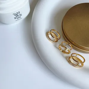 Detailed view of fashionable gold-plated double-layer geometric rings with sparkling cubic zirconia.