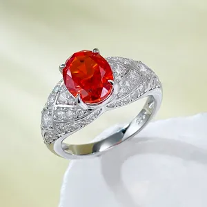 Close-up detail of silver oval sunset orange high-carbon diamond ring with pave side stones.