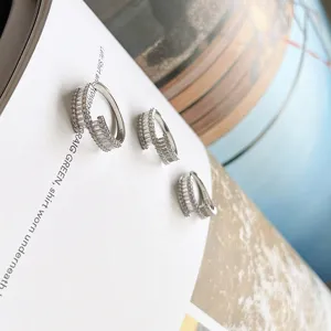 Vista detallada de anillos de plata con cristales baguette y pavé fino diseño de capas elegante.