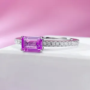 Closeup detail of the elegant emerald-cut pink gemstone silver ring with pave band sparkle.
