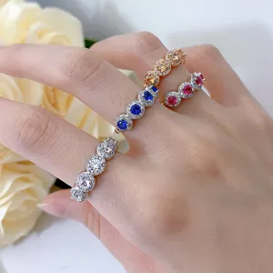 Close-up display of stunning multi-stone halo rings with sparkly clear and colorful gems.