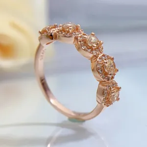 Close-up detail of multi-stone halo rose gold ring with sparkling champagne stones.