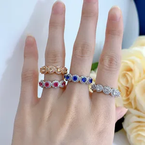 Detailed shot of multi-color crystal cluster eternity rings worn on hand, elegant silver jewelry.