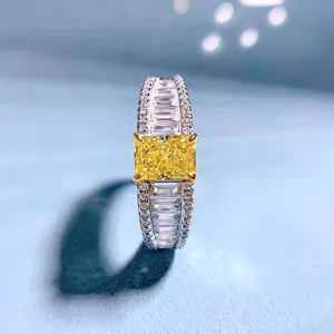 Nahaufnahme eines gelben Diamantrings im Radiant-Schliff mit funkelnden Schmucksteinen.
