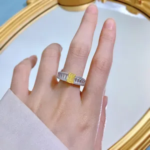 Detailansicht eines funkelnden Ringes mit gelbem Diamanten im Baguettedesign an Hand.