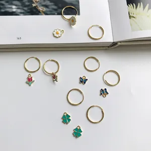 Goldfarbene Creolen Set mit bunten Emailleschmuckstücken wie Gänseblümchen und Schmetterlingen.