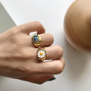 Vergoldetes Ringdetail mit farbigen Emailleschmetterlingen und Gänseblümchen-Anhänger.
