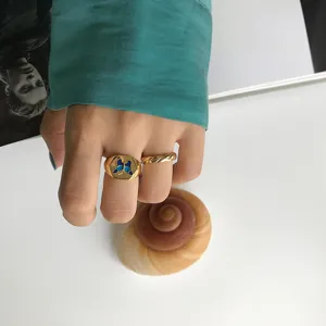 Goldener Siegelring mit blauem Schmetterling und filigranem gedrehten Band für Damen.