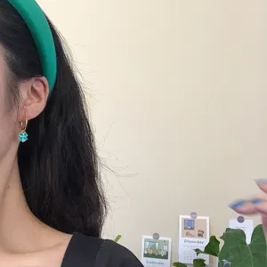 Elegante türkise vierblättrige Kleeblatt Creolen für Damen, stilvoller minimalistischer Schmuck.