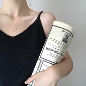 Λεπτομέρεια χρυσού κολιέ με ακανόνιστο μενταγιόν κύκλου C και εξαιρετική μεταλλική υφή.