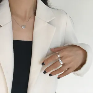 Detailaufnahme von silberner Halskette und Ringen, elegante Schmuckpräsentation nah.