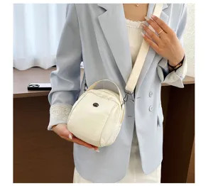 Detailed view of the stylish white crossbody shell bag worn by model in a chic daily outfit.