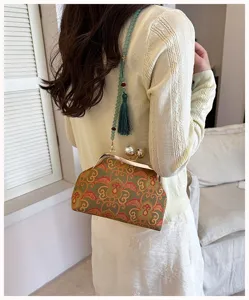Detailweergave van de Chinese stijl brokaat schelp tas met parelsluiting en kralenriem.