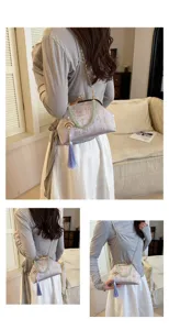 Chinese style jacquard kiss-lock evening bag with pearl tassel pendant and chain strap.