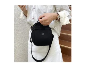 Classic black shell shoulder bag with metal logo, casual stylish minimalist crossbody design.