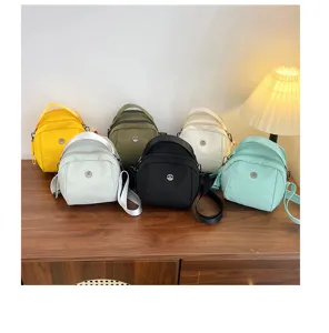 Detailed shot of multi-color casual shell bags with shoulder straps and metal badge accents.