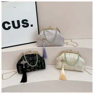 Chinese style jacquard kiss-lock evening bag with pearl tassel pendant and metal chain.