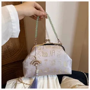 Chinese style kiss-lock evening bag with jade bead handle, jacquard embroidery and pearl tassel.