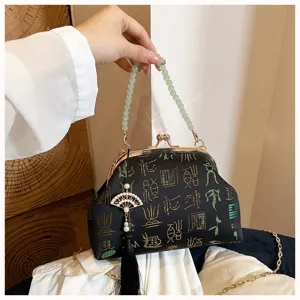 Detail shot of Chinese retro embroidered evening bag featuring bead handle and tassel pendant.