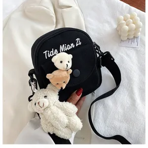 Black canvas crossbody bag with cute plush bear pendant, stylish casual student shoulder bag.