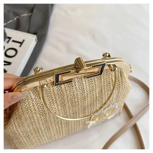 Chic sac pochette en paille tressée avec cadre métallique et poignée pour l'été.