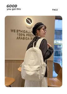 Casual white backpack detail showcasing multi-pocket design and canvas texture in cafe scene.