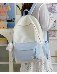 Detail view of cute Japanese style star print school backpack with plush pendant and front pocket.