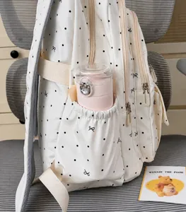 Dettaglio tasca laterale zaino a pois con fiocco, graziosa borsa scolastica per donne e studentesse.