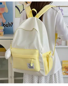 Detailed view of the cute yellow and white star print school backpack worn by model.