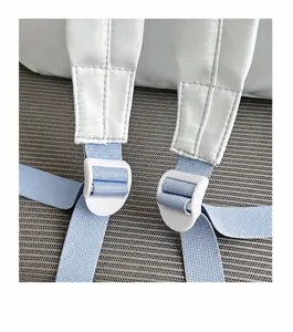 Close-up detail of student backpack adjustable shoulder strap and buckle in light blue.