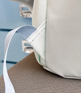 Backpack detail view showing durable triangle strap reinforcement and precise stitching.