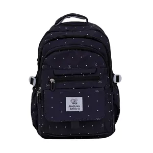 Vista dettagliata di uno zaino carino blu scuro a pois e fiocchi per donne, borsa da scuola.