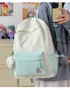 Detailed view of the mint green and white canvas backpack with cute star prints and front pocket.