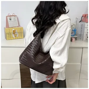 Detailed view of dark brown woven leather shoulder bag, chic underarm design for commute.