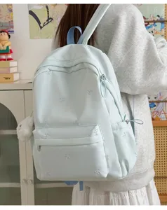 Light blue student backpack with cute embroidered bows, casual nylon school bag for teen girls.