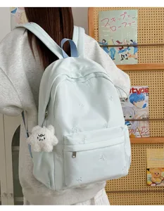 Korean style student backpack with cute bow embroidery and soft plush pendant for daily use.