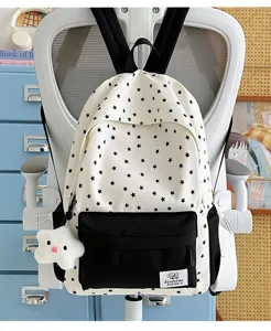 Detail view of casual student backpack with black star print and plush star pendant charm.