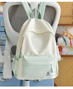 Backpack detail showing star print pattern and front pocket design in light green and cream.