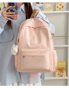 Detailed view of cute pink school backpack with embroidered bows, lightweight student daypack.