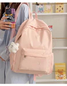 Pink student backpack with cute embroidered bows, casual nylon daypack for school daily use.