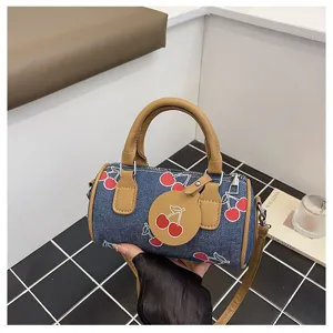 Denim cherry print barrel bag with brown handle, stylish casual shoulder crossbody handbag.