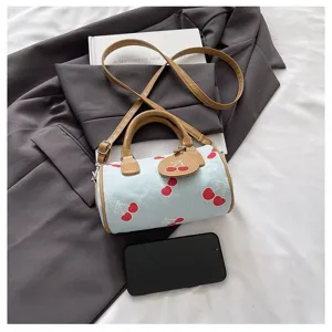Close-up detail of the cute cherry print pillow handbag with brown leather handles and strap.