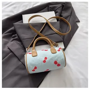 Close-up detail of the light blue cherry print pillow bag, featuring brown handles and chic style.